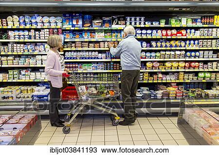 "Senior couple shopping with a shopping trolley in the refrigerated dairy section in a supermarket, Germany, Europe" View Large Photo Image Stock Image - "Senior couple shopping with a shopping trolley in the refrigerated dairy section in a supermarket, Germany, Europe". Fotosearch