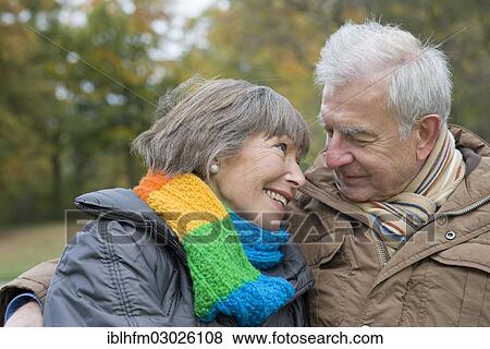 "Senior couple sitting arm in arm on a park bench, smiling at each other, Stadtpark, Berlin, Berlin, Germany, Europe" View Large Photo Image Stock Photo - "Senior couple sitting arm in arm on a park bench, smiling at each other, Stadtpark, Berlin, Berlin, Germany, Europe". Fotosearch