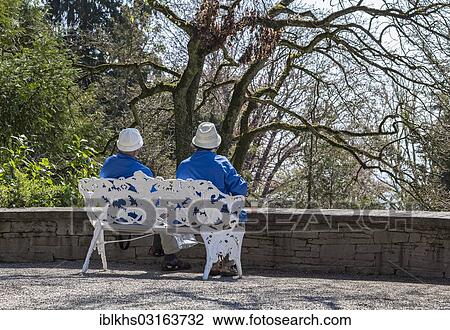 "Senior couple sitting on a bench in a park, Mainau, Baden-Wurttemberg, Germany, Europe" View Large Photo Image Stock Image - "Senior couple sitting on a bench in a park, Mainau, Baden-Wurttemberg, Germany, Europe". Fotosearch