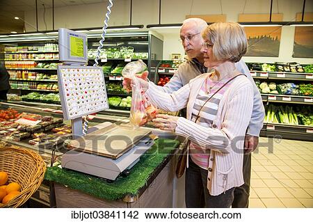 "Senior couple weighing fruit at the self-service scales while shopping in the fruit and vegetables department of a supermarket, Germany, Europe" View Large Photo Image Stock Image - "Senior couple weighing fruit at the self-service scales while shopping in the fruit and vegetables department of a supermarket, Germany, Europe". Fotosearch