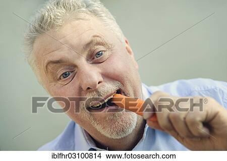 "Senior eating a carrot with pleasure, Grevenbroich, Rhineland, North Rhine-Westphalia, Germany, Europe" View Large Photo Image Picture - "Senior eating a carrot with pleasure, Grevenbroich, Rhineland, North Rhine-Westphalia, Germany, Europe". Fotosearch