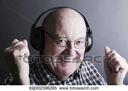 "Senior wearing headphones, looking pleased" View Large Photo Image Stock Photography - "Senior wearing headphones, looking pleased". Fotosearch