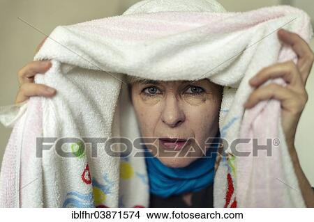 Picture - "Senior woman with a cold inhaling under a towel, Germany, Europe". Fotosearch