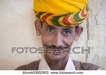 Stock Image - "Servant wearing a yellow turban and earrings, portrait, Mehrangarh Fort, Jodhpur, Rajasthan, India, Asia". Fotosearch