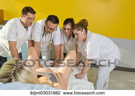 "Several doctors and midwives with concerned expressions looking between the legs of a woman during childbirth, Germany, Europe" View Large Photo Image Stock Image - "Several doctors and midwives with concerned expressions looking between the legs of a woman during childbirth, Germany, Europe". Fotosearch