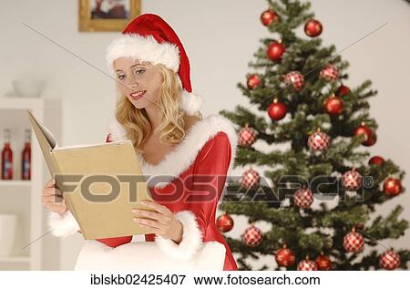 Sexy Miss Santa reading a golden book in a Christmas environment View Large Photo Image Stock Photo - Sexy Miss Santa reading a golden book in a Christmas environment. Fotosearch