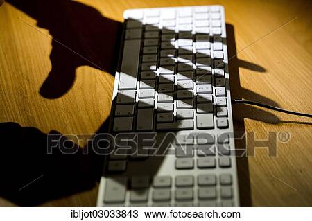 "Shadows of two hands on a computer keyboard, one hand holding a credit card, symbolic image for cybercrime, data security, computer security" View Large Photo Image Stock Image - "Shadows of two hands on a computer keyboard, one hand holding a credit card, symbolic image for cybercrime, data security, computer security". Fotosearch
