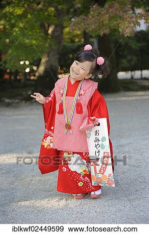 "Shichi-go-san, Seven-Five-Three festival, girl in a red kimono holding a long bag with candy canes, Chitose-ame, standing on the gravel at the Shimogamo shrine in Kyoto, Japan, East Asia, Asia" View Large Photo Image Stock Photo - "Shichi-go-san, Seven-Five-Three festival, girl in a red kimono holding a long bag with candy canes, Chitose-ame, standing on the gravel at the Shimogamo shrine in Kyoto, Japan, East Asia, Asia". Fotosearch