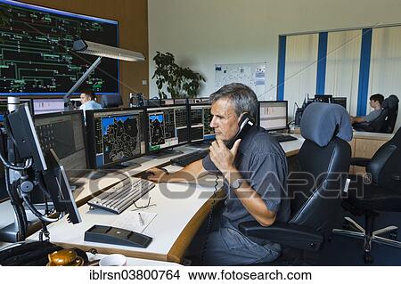 "Shift supervisor Hans-Peter Polzer sitting at his work station in the Transmission Control Center, TCC, of transmission network operator 50Hertz, Neuenhagen, Brandenburg, Germany, Europe" View Large Photo Image Picture - "Shift supervisor Hans-Peter Polzer sitting at his work station in the Transmission Control Center, TCC, of transmission network operator 50Hertz, Neuenhagen, Brandenburg, Germany, Europe". Fotosearch