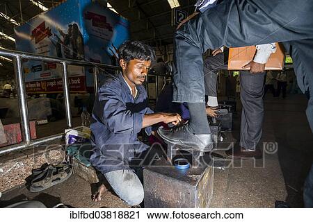 Stock Image - "Shoeshine working inside Churchgate Railway Station, Mumbai, Maharashtra, India, Asia". Fotosearch