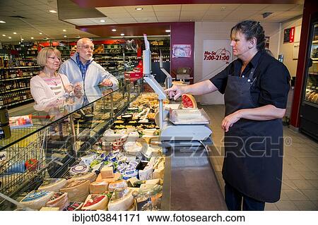 "Shop assistant serving a senior couple at the cheese counter, shopping in a supermarket, Germany, Europe" View Large Photo Image Stock Image - "Shop assistant serving a senior couple at the cheese counter, shopping in a supermarket, Germany, Europe". Fotosearch