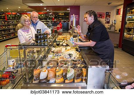 "Shop assistant serving a senior couple at the cheese counter, shopping in a supermarket, Germany, Europe" View Large Photo Image Stock Image - "Shop assistant serving a senior couple at the cheese counter, shopping in a supermarket, Germany, Europe". Fotosearch