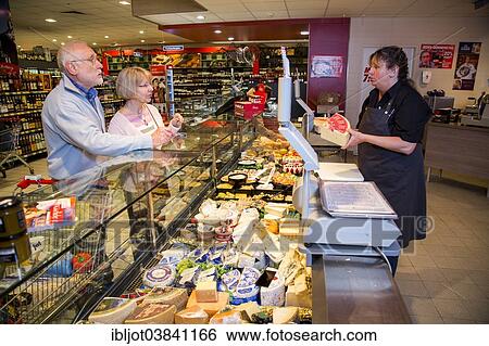 "Shop assistant serving a senior couple at the cheese counter, shopping in a supermarket, Germany, Europe" View Large Photo Image Stock Photograph - "Shop assistant serving a senior couple at the cheese counter, shopping in a supermarket, Germany, Europe". Fotosearch