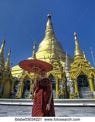 "Shwedagon Pagoda, monk holding an umbrella standing in front of the golden stupa and the golden chedis, Rangun, Yangon Region, Myanmar, Burma, Asia" View Large Photo Image Stock Image - "Shwedagon Pagoda, monk holding an umbrella standing in front of the golden stupa and the golden chedis, Rangun, Yangon Region, Myanmar, Burma, Asia". Fotosearch
