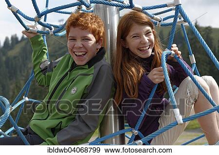 "Siblings, children sitting in a climbing frame at the playground at Jagahuttn auf der Sutten, Tegernsee Mountains, Upper Bavaria, Bavaria, Germany, Europe" View Large Photo Image Stock Photo - "Siblings, children sitting in a climbing frame at the playground at Jagahuttn auf der Sutten, Tegernsee Mountains, Upper Bavaria, Bavaria, Germany, Europe". Fotosearch