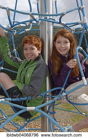 "Siblings, children sitting in a climbing frame at the playground at Jagahuttn auf der Sutten, Tegernsee Mountains, Upper Bavaria, Bavaria, Germany, Europe" View Large Photo Image Stock Photograph - "Siblings, children sitting in a climbing frame at the playground at Jagahuttn auf der Sutten, Tegernsee Mountains, Upper Bavaria, Bavaria, Germany, Europe". Fotosearch