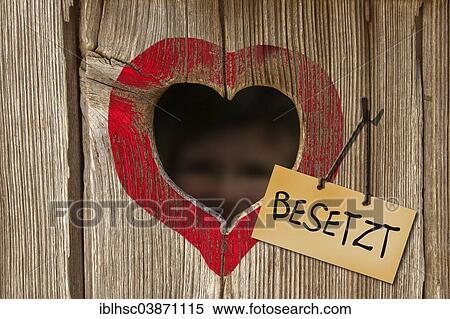 "Sign """"Besetzt"""", German for """"Occupied"""", next to the heart-shaped hole of a toilet house" View Large Photo Image Stock Photography - "Sign """"Besetzt"""", German for """"Occupied"""", next to the heart-shaped hole of a toilet house". Fotosearch