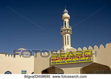 Stock Photography - "Sign of a business for household goods and electrical appliances in front of a mosque, Al Hamra, Ad Dakhiliyah, Oman, Asia". Fotosearch