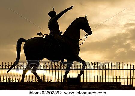 Stock Image - "Silhouette of the equestrian statue of Rao Jodha Ji, near Jaswant Thada, with the rider pointing towards Mehrangarh Fort, Jodhpur, Rajasthan, India, Asia". Fotosearch