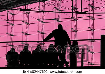 Stock Image - "Silhouettes of travellers waiting for trains in the main station building, backlit, Berlin, Germany, Europe". Fotosearch