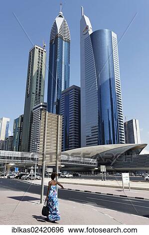 Stock Photograph - Single pedestrian in front of skyscrapers, Sheikh Zayed Road, Dubai International Financial Centre, DIFC, Dubai, United Arab Emirates, Middle East, Asia. Fotosearch