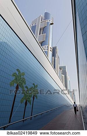 Stock Photo - Single person walking through a pedestrian underpass with painted palm trees, Sheikh Zayed Road, Dubai, United Arab Emirates, Middle East, Asia. Fotosearch
