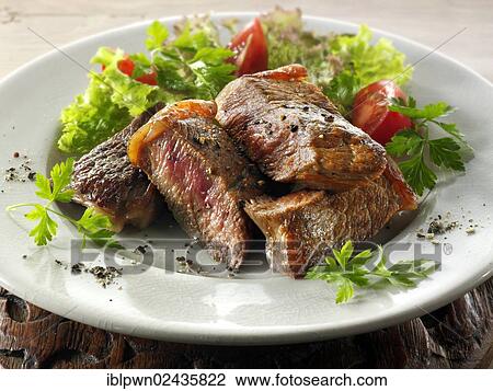Stock Image - Sirloin steak with salad. Fotosearch