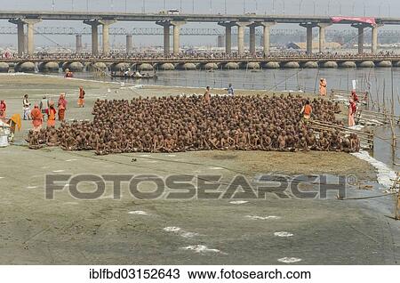 Stock Image - "Sitting in silence as part of the initiation of new sadhus at the Sangam, the confluence of the rivers Ganges, Yamuna and Saraswati, during Kumbha Mela festival, Allahabad, Uttar Pradesh, India, Asia". Fotosearch
