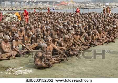 Stock Image - "Sitting in silence as part of the initiation of new sadhus at the Sangam, the confluence of the rivers Ganges, Yamuna and Saraswati, during Kumbha Mela festival, Allahabad, Uttar Pradesh, India, Asia". Fotosearch