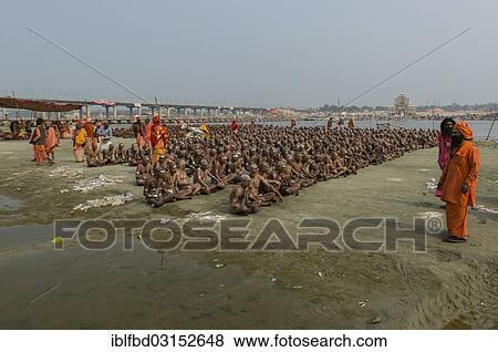 Stock Photo - "Sitting in silence as part of the initiation of new sadhus at the Sangam, the confluence of the rivers Ganges, Yamuna and Saraswati, during Kumbha Mela festival, Allahabad, Uttar Pradesh, India, Asia". Fotosearch