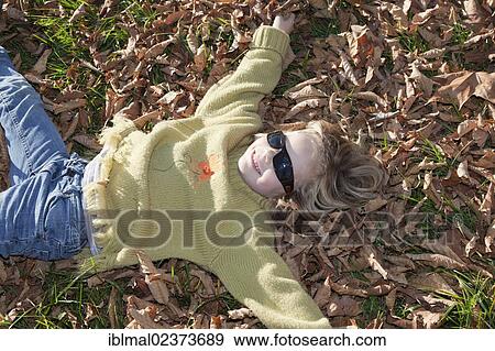 Six-year-old girl playing in the autumn leaves View Large Photo Image Stock Photo - Six-year-old girl playing in the autumn leaves. Fotosearch