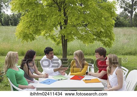 "Six young people having a discussion around a round table in a garden, Hagen, Lower Saxony, Germany, Europe" View Large Photo Image Picture - "Six young people having a discussion around a round table in a garden, Hagen, Lower Saxony, Germany, Europe". Fotosearch