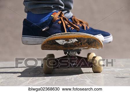 Stock Image - "Skater, feet standing on a skateboard, Blaubeuren skate park, Baden-Wuerttemberg, Germany, Europe, PublicGround, Europe". Fotosearch
