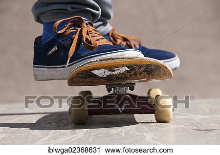 Stock Image - "Skater, feet standing on a skateboard, Blaubeuren skate park, Baden-Wuerttemberg, Germany, Europe, PublicGround, Europe". Fotosearch