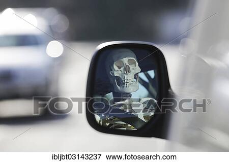 Stock Photo - "Skeleton at the wheel of a car, skull reflected in the wing mirror of a car, Germany, Europe". Fotosearch