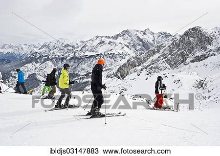 Stock Image - "Skiers and mountain landscape at Mt Osterfelderkopf, Garmisch-Partenkirchen, Upper Bavaria, Bavaria, Germany, Europe". Fotosearch