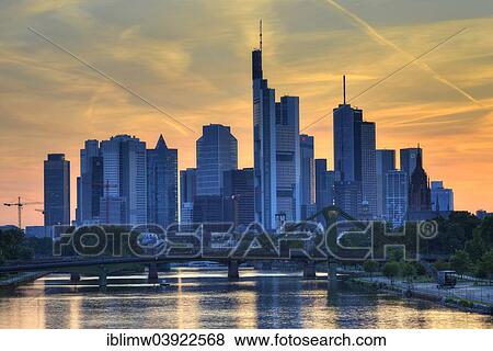 Stock Photo - "Skyline at dusk, TaunusTurm, Tower 185, Commerzbank, Messeturm, ECB, European Central Bank, Helaba, Landesbank Hessen, Deutsche Bank, Frankfurt Cathedral, Flosserbrucke bridge, Frankfurt am Main, Hesse, Germany, Europe". Fotosearch