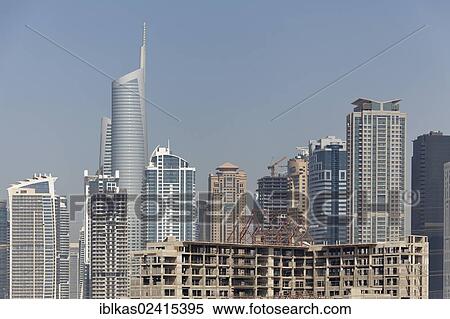 Stock Photography - Skyline, Jumeirah Lake Towers and a discontinued construction site with the building shell, Dubai, United Arab Emirates, Middle East, Asia. Fotosearch