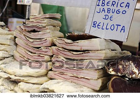 Stock Photo - "Slabs of bacon stacked in market stall at the annual All Saints Market in Cocentaina, Alicante province, Spain, Europe". Fotosearch