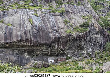 Stock Photo - "Small wooden houses protected under a huge rock wall, Jossingfjord, Sud-Norwegen, Rogaland, Western Norway, Norway, Europe". Fotosearch