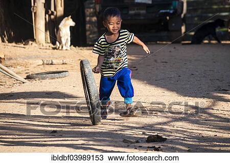 "Smiling boy from the Lahu people, hill tribe, ethnic minority, plays with a motorcycle tyre, Mae Hong Song Province, Northern Thailand, Thailand, Asia" View Large Photo Image Stock Image - "Smiling boy from the Lahu people, hill tribe, ethnic minority, plays with a motorcycle tyre, Mae Hong Song Province, Northern Thailand, Thailand, Asia". Fotosearch