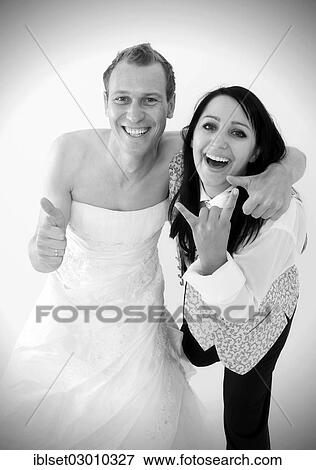 "Smiling bride wearing a suit and a groom wearing a wedding dress, exchange of wedding clothing, Austria, Europe" View Large Photo Image Stock Photo - "Smiling bride wearing a suit and a groom wearing a wedding dress, exchange of wedding clothing, Austria, Europe". Fotosearch