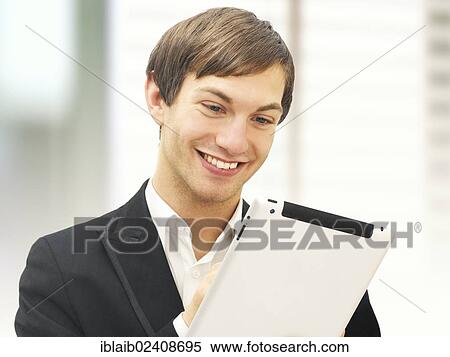 Stock Photography - Smiling businessman holding an iPad. Fotosearch