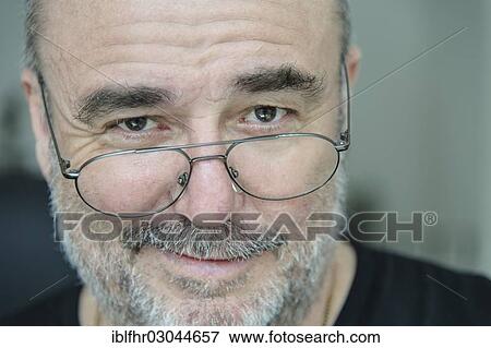 "Smiling elderly man looking over his glasses, portrait, Grevenbroich, Rhineland, North Rhine-Westphalia, Germany, Europe" View Large Photo Image Stock Photo - "Smiling elderly man looking over his glasses, portrait, Grevenbroich, Rhineland, North Rhine-Westphalia, Germany, Europe". Fotosearch
