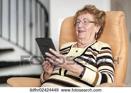 Smiling elderly woman reading an eBook, Germany, Europe View Large Photo Image Stock Photo - Smiling elderly woman reading an eBook, Germany, Europe. Fotosearch