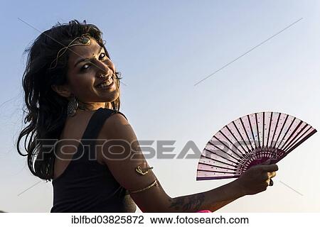 Stock Image - "Smiling Indian woman with a fan, Goa, India, Asia". Fotosearch