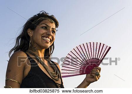 Stock Photography - "Smiling Indian woman with a fan, Goa, India, Asia". Fotosearch