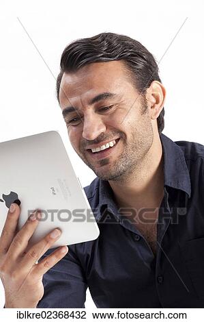 Smiling man holding an iPad View Large Photo Image Stock Image - Smiling man holding an iPad. Fotosearch