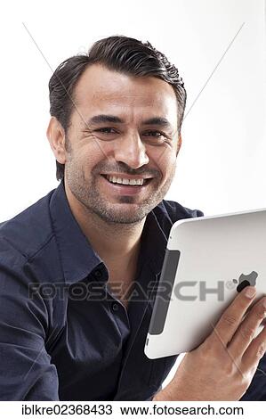 Smiling man holding an iPad View Large Photo Image Stock Image - Smiling man holding an iPad. Fotosearch