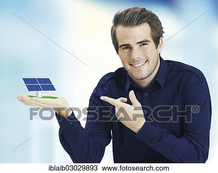 Smiling man pointing to solar cell in his hand View Large Photo Image Stock Image - Smiling man pointing to solar cell in his hand. Fotosearch